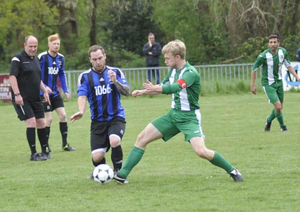 Allan McMinigal goes in for a tackle during Hollington United's 3-1 win at home to Rotherfield. Pictures by Simon Newstead