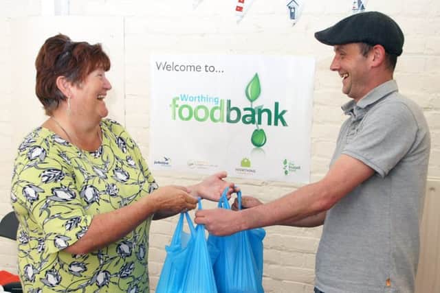 Aaron Payne collects his food parcel from Worthing Foodbank manager Julie Denyer. Photo by Derek Martin DM1942555a
