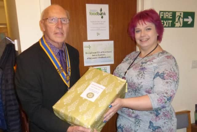 Samantha Gouldson, deputy co-ordinator of Littlehampton and District Foodbank, receiving a donation from Littlehampton Rotary Club president Bruce Green