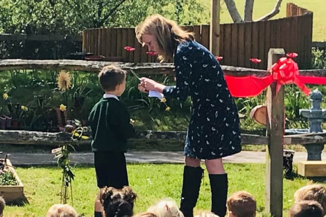 Ashington CE Primary School headteacher Pip Fairweather with year-two pupil Jimmy cutting the ribbon at the grand ceremony reporning of the prayer garden SUS-190105-140022001