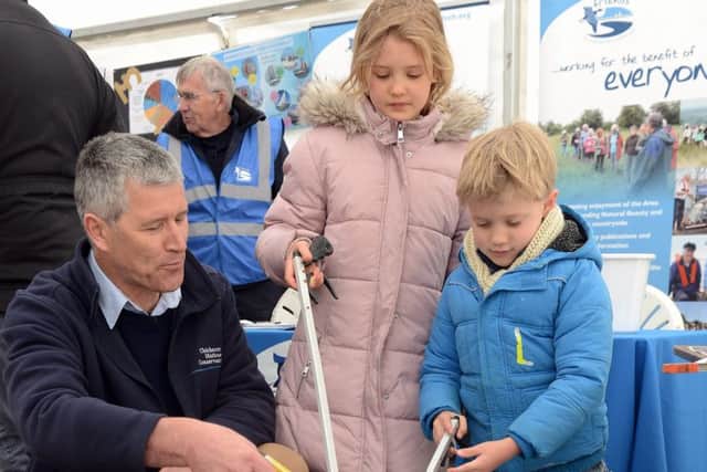 Harbour master demonstrating litter picking with Sophie Cath, nine, and her brother Toby, five