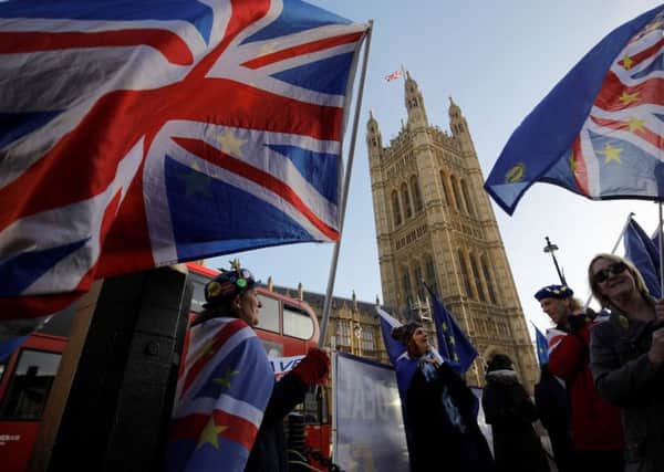 Anti-brexit campaigners wave Union and EU flags outside the Houses of Parliament SUS-190124-085826001