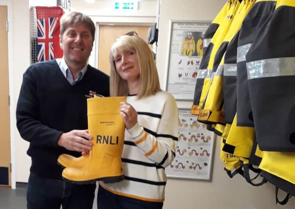 Steve Smith, Shoreham RNLI coxswain, hands the RNLI Mayday Welly to Karen Hilton, Mile Oak Football Club press officer