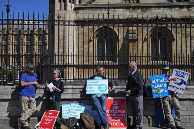 Pro-Brexit and anti-Brexit activists stand in the afternoon sunshine with their placards outside the Palace of Westminster in central London on May 13, 2019. (Photo by DANIEL LEAL-OLIVAS/AFP/Getty Image)