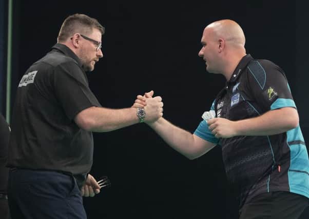 Rob Cross (right) shakes hands with James Wade at the end of their match. Picture courtesy Lawrence Lustig/PDC