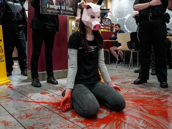 A protester surrounded by fake blood in McDonald's