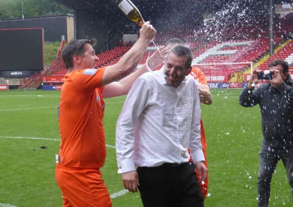 Battle Baptists manager Kyle Mann gets a drenching from Steve McGowan during the post-match celebrations. Picture by Simon Newstead