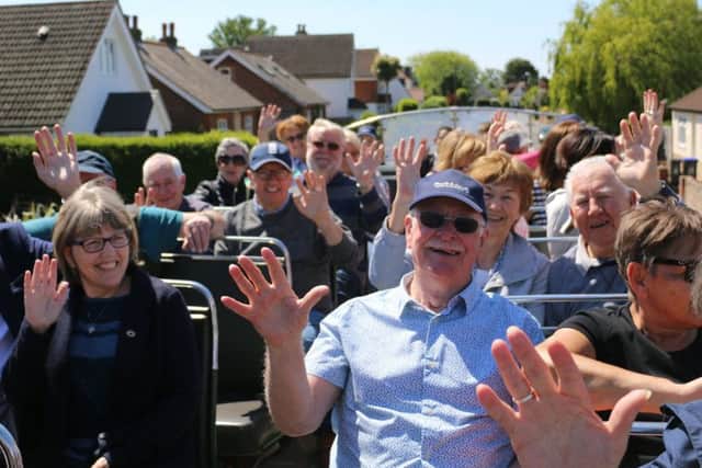 Passengers on the Dementia Action Day bus wave from the top deck
