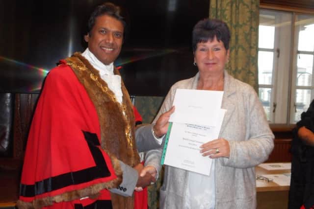 Outgoing mayor Councillor Abul Azad presents certificate to Bexhill Caring Community. Photo by Margaret Garcia