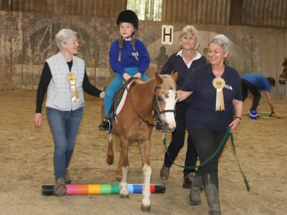 Kingley Vale Riding school for the disabled awarded money. Poppy aged 8 riding a pony called Poppy, helped by Judy Paige, Barbara and Julia Bridger, right. Photo by Derek Martin Photography.