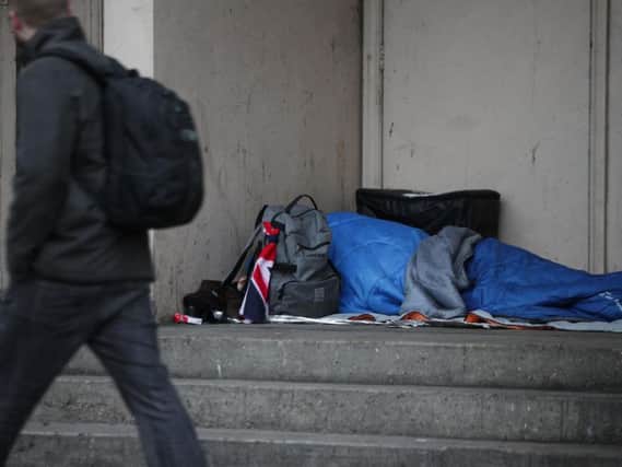 A person sleeping rough in a doorway.