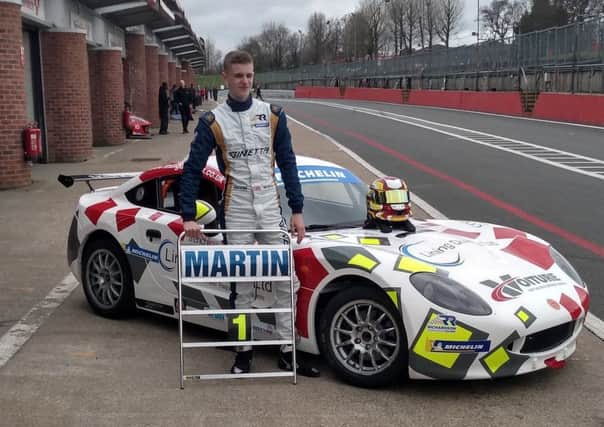 Talented young racing driver Will Martin stands proudly alongside his car
