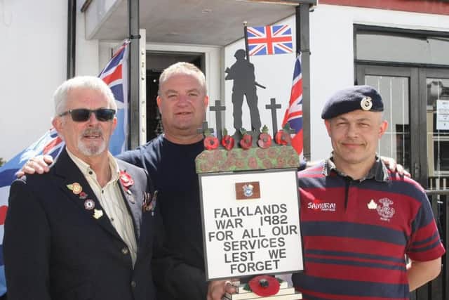 Wooden soldier statue made by Men in Sheds donated to Veterans Clubin Littlehampton and ending up at a church in the Falklands. Roy Amos presents it to Ian Neville, accomapanied by Cllr Ian Buckland. Photo by Derek Martin Photography.