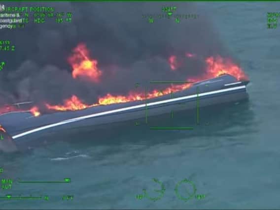 A screenshot from the video shows the yacht capsized and ablaze. Picture via the Maritime and Coastguard Agency
