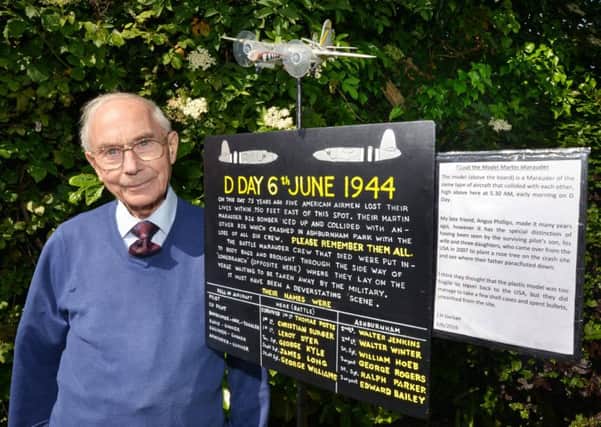 John Gerken with his memorial sign commemorating five American men who lost their lives 750 feet from his house on D-Day 1944
