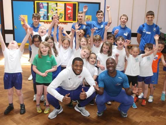 Nathan Fox, left, and Adrian Patrick with athletes from St Andrew's High School and pupils from Springfield Infant School. Photo by Derek Martin DM1961697a