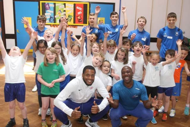 Nathan Fox, left, and Adrian Patrick with athletes from St Andrew's High School and pupils from Springfield Infant School. Photo by Derek Martin DM1961697a