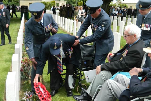 Tom, assisted by serving RAF personnel, lays a wreath at the Bayeux SUS-191206-124518001