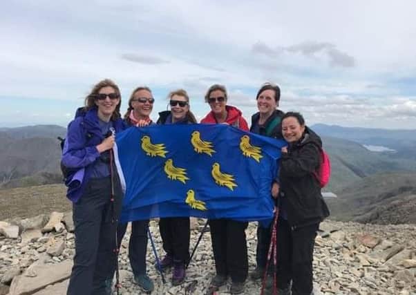 Martlet Mountaineers, friends Linda Evans, Christine Gillott, Linda Doughty, Sue Eden, Sharon Fisher and Debbie Fisher fly the Sussex flag at Scafell Pike