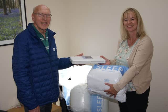 Littlehampton Rotary Club president Bruce Green hands over bedding and towels to Louise Gisbey, development and sustainability manager at Safe in Sussex