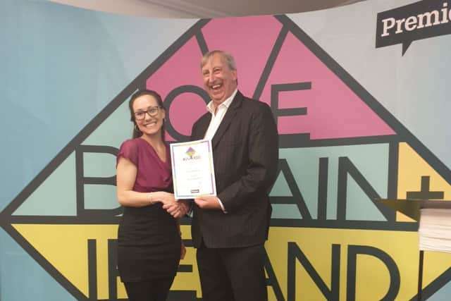 Rosie Downham, a supporter of Time to Talk Befriending, accepts the Love Britain + Ireland Award from Premier chief executive Peter Kerridge
