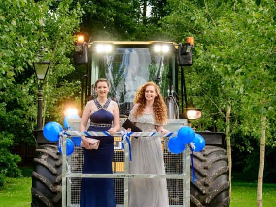 Catherine Westgate (left) and Scarlett Weg arrive at the prom at Broyle Place via tractor.