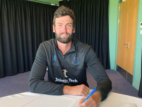 Reece Topley signs for Sussex. Picture courtesy of Sussex Cricket
