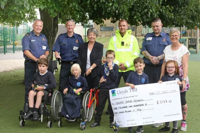 HM Coastguard Shoreham presents a cheque to Herons Dale Primary School for the all terrain wheelchair, supported by Jane Self from Nicosy. Picture: Derek Martin DM1971539a