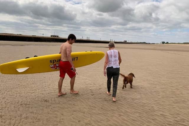 Karen and the lifeguard that rescued her, on Camber beach. Photo by Kt Bruce. SUS-190716-094134001
