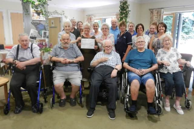 Staff and residents at Highdown Court in Worthing present a cheque to Maureen Johnson, sub branch organiser at Worthing and Washington Parkinson's UK