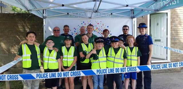Conrad Roskell of Raven Housing Trust (back row, left) with the new junior neighbourhood wardens, Ravens neighbourhood wardens and Surrey police.