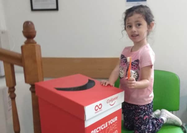 One of East Mews Dental Care's young patients, Lavinia, bringing back some old products for recycling to the Horsham practice SUS-190209-151747001