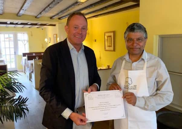 Nick Herbert MP presenting owner Sanjay Jha with the certificate and Tiffin Cup apron