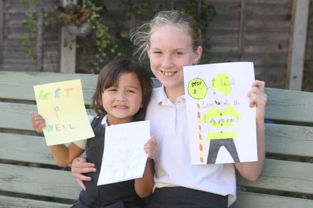 DM1992693a.jpg. Pupils at Billingshurst Primary School are hoping lollipop man John Gooderham will recover soon after a crash outside the school that left him with broken ribs. Willow Parsons, four, and Lily Smith, nine. Photo by Derek Martin Photography.