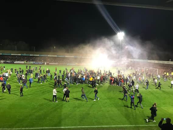 Crawley fans celebrate by invading the pitch after Ollie Palmer's winning penalty