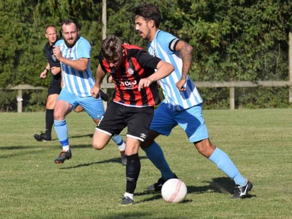 AFC Uckfield Town captain Richie Welch puts a Saltdean United player under pressure as Sam Cooper watches on. Picture by Mike Skinner