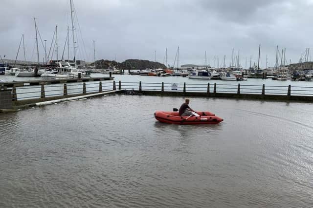 A man rowing across the marina car park in his boat. Picture: Morgan Carn Architects