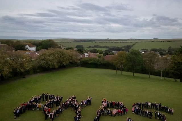 Pupils and staff spell out the school's name to celebrate its 60th anniversary