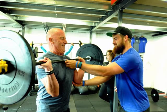 Owner and head coach, Ben Price, right, helping a gym member. Photo: Kate Shemilt ks190554-2