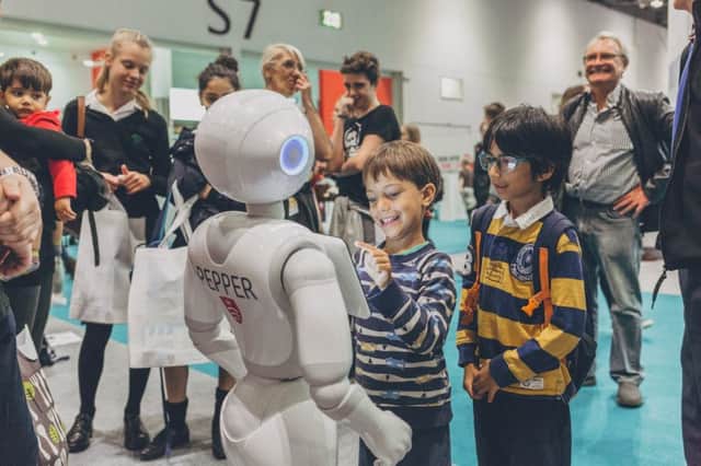 Children interact with a robot at the science fair