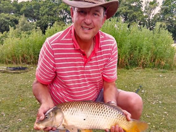 Steve Penticost with a carp, whose name has yet to be confirmed