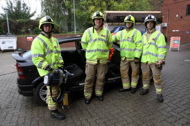 Fire and rescue personnel pose in front of a crash vehicle for a demonstration, photo by Ron Hill