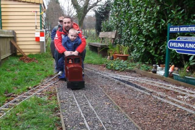 Dad, Darryl, and Riley with grandad Larry driving at the back of a miniature locomotive