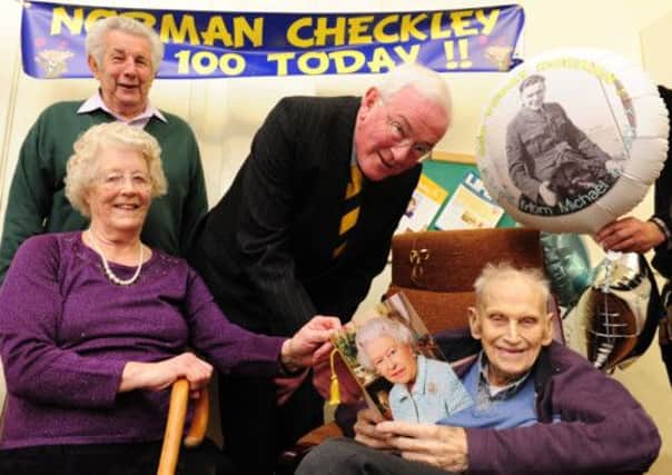 JPCT 210313 Norman Checkley's 100th birthday.  Deputy Lieutenant of West Sussex Col. Richard Putnam, hands over a card from the Queen accompanied by friends Ada and Reg Mitchell. Photo by Derek Martin
