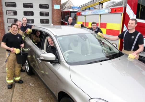 Eric Boulter from Angmering has his car washed by firefighters as part of their charity car wash day, at Littlehampton fire station PICTURE: Chris Hatton