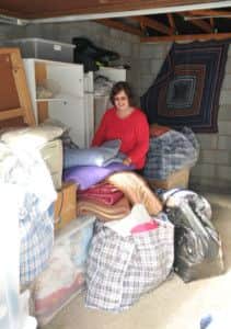 Horsham Winter Night Shelter project co-ordinator Hazel Lamb surrounded by donations of bedding and toiletries - Pure Photography