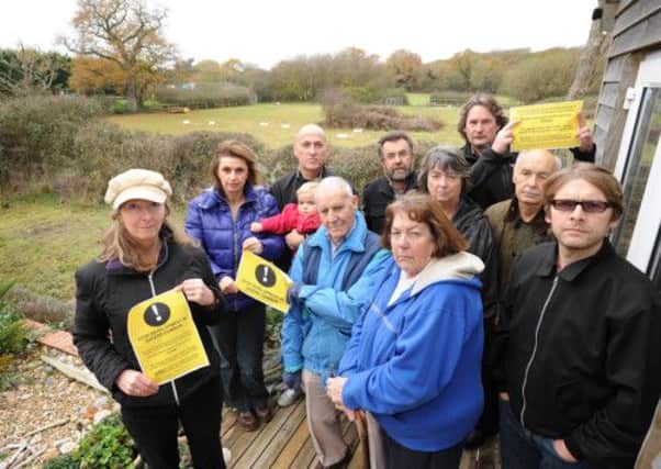 Protestors from Dunlop Close, Sayers Common in a back garden of one of the residents, with a view across the fields that will be built on, in the background.
