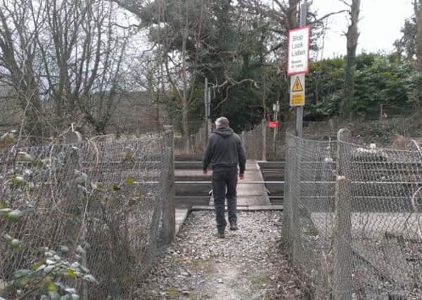 A walker tries to cross the double lines across the London to Brighton line at Balcombe