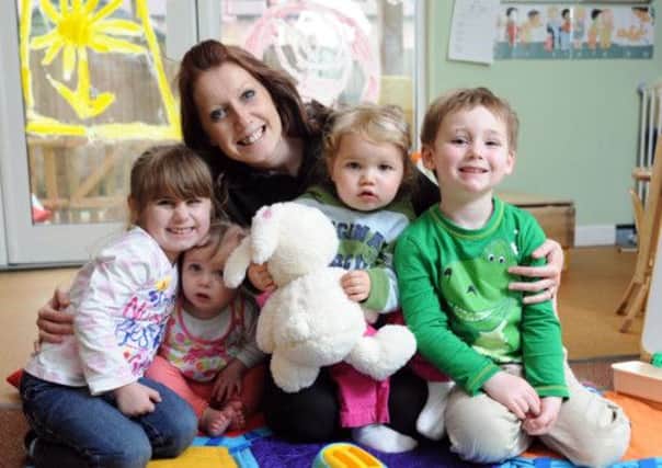 Nursery manager Melanie Ruffell and children celebrating their Ofsted     L16276H13