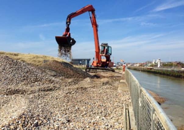 An excavator removes shingle from the mouth of Littlehampton harbour